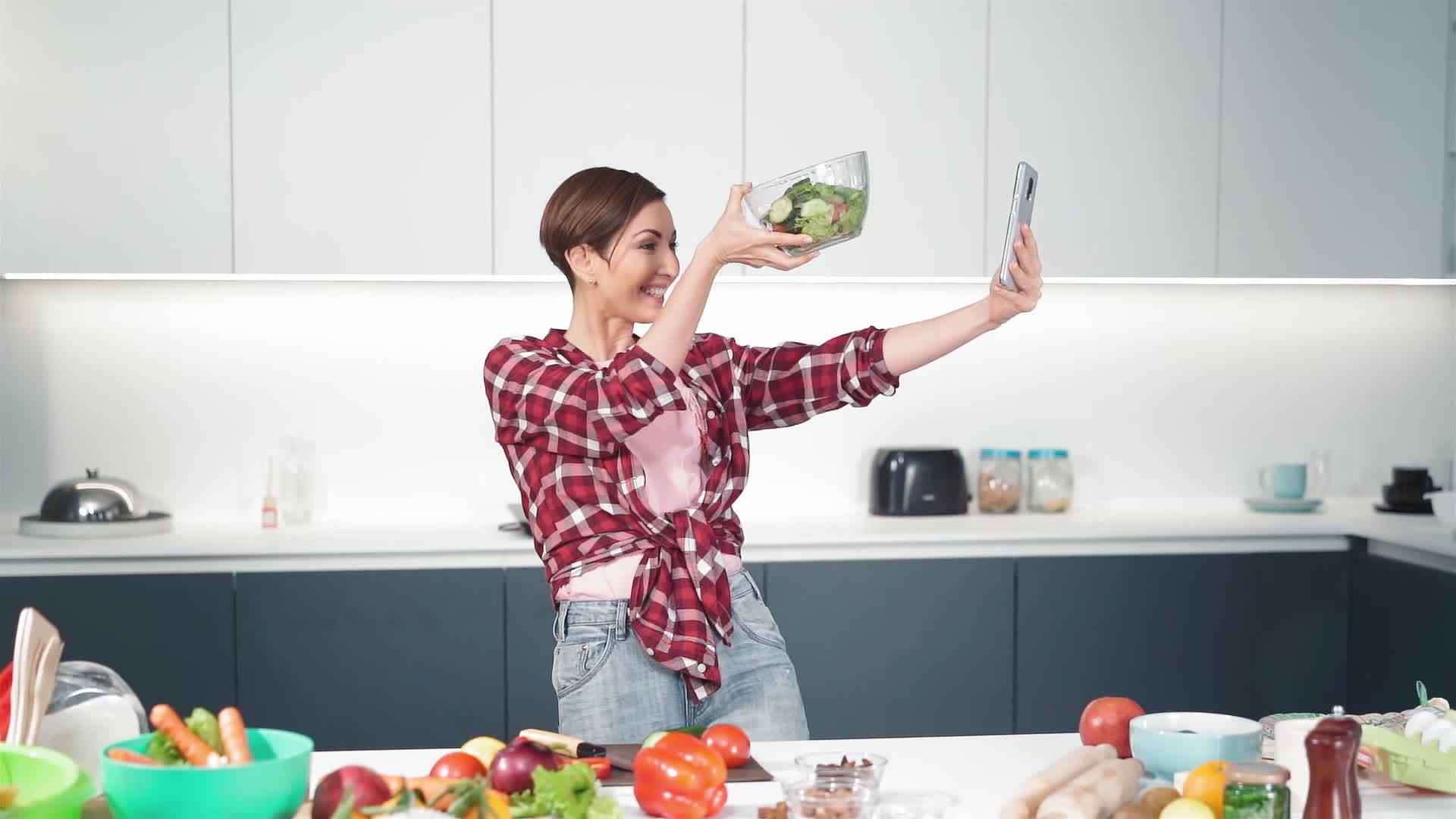 一位快乐的家庭主妇用她的智能手机自拍了一大碗新鲜沙拉视频的预览图