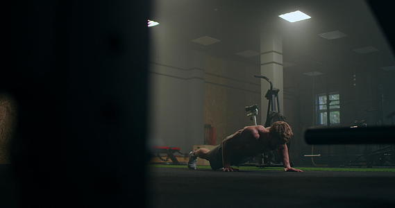 一个强壮的男人尽力从地板上做俯卧撑一个精力充沛的男人在健身房做俯卧撑视频的预览图