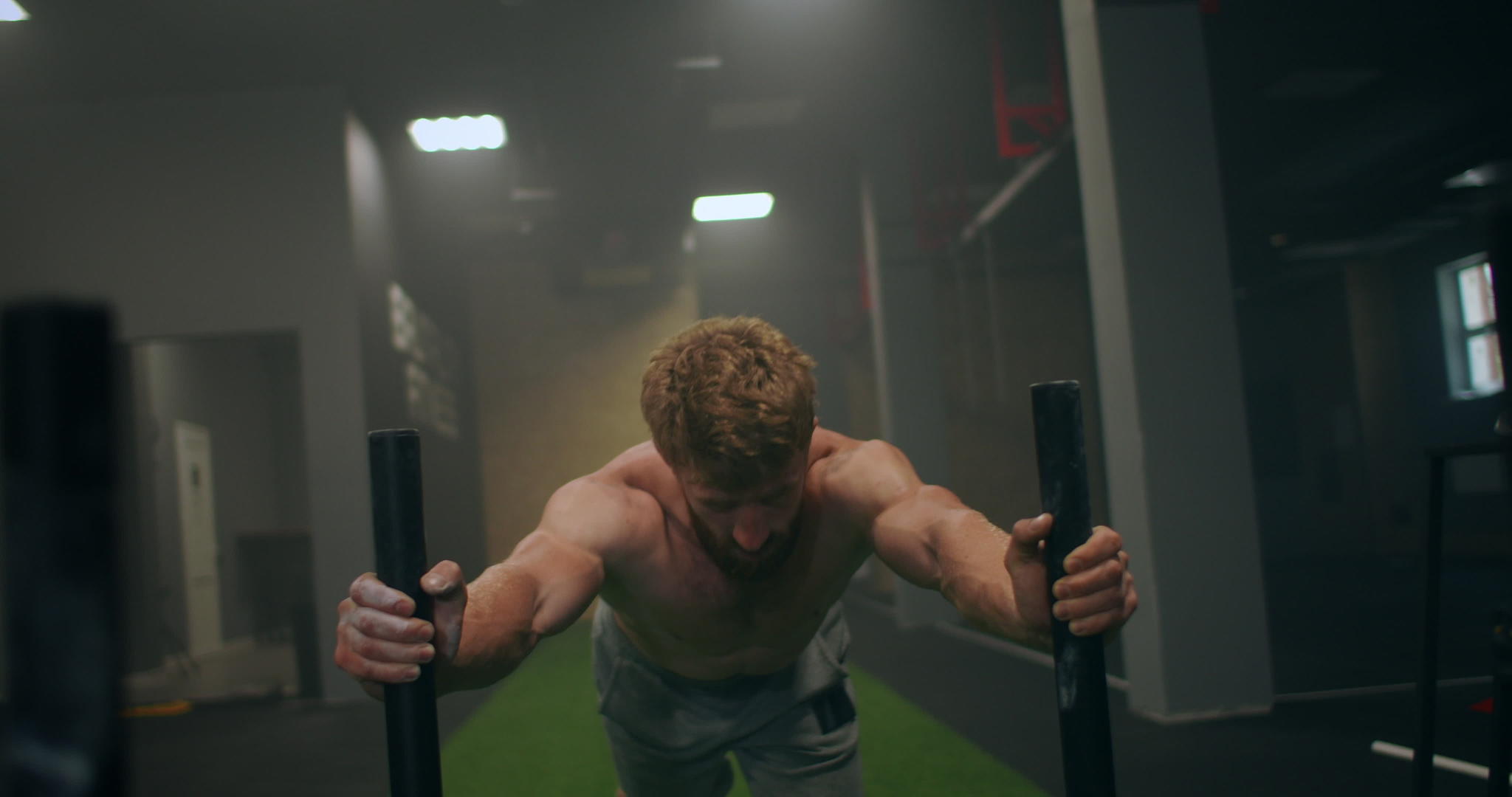 一名强壮的单心男运动员在健身房推了一个重雪橇视频的预览图