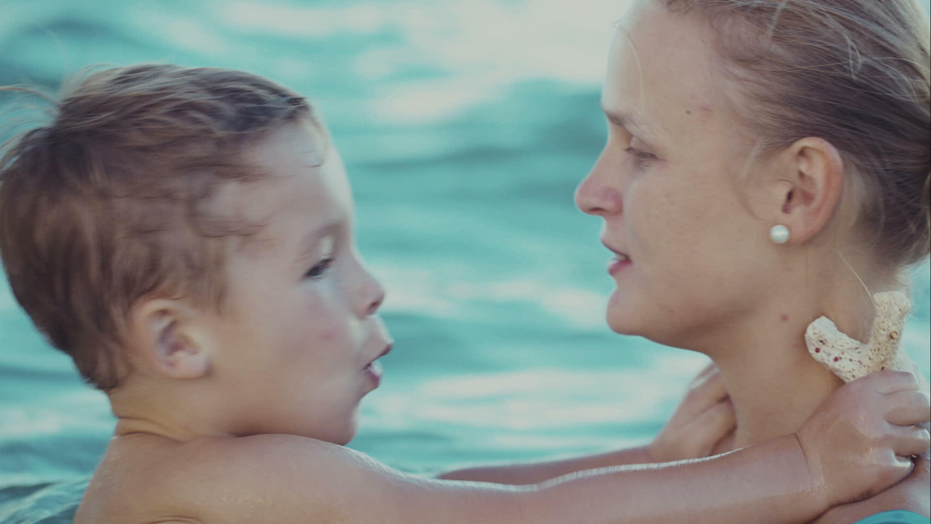 男孩在海里洗澡时亲吻母亲视频的预览图