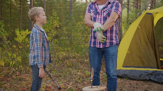 父亲和儿子在森林里砍柴视频的预览图