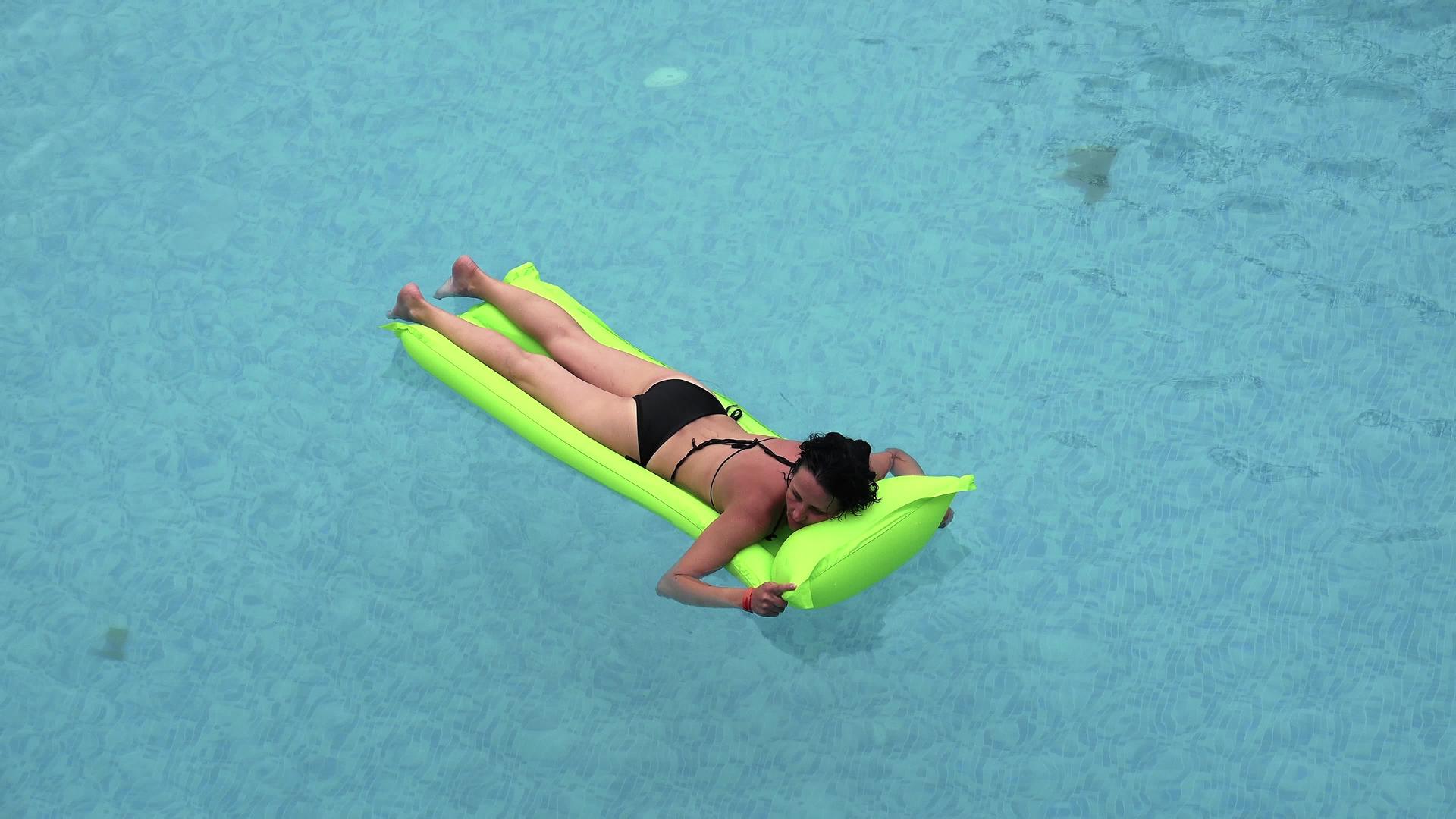 在游泳池的绿色充气床垫上放松视频的预览图