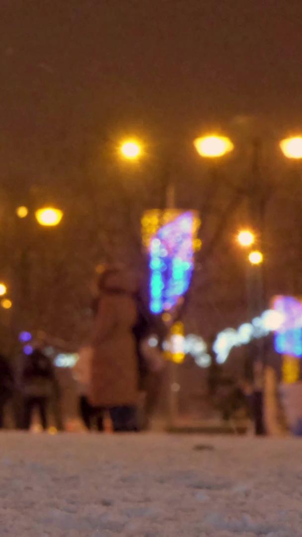 冬季下雪的夜晚城市低角度拍摄行人视频的预览图