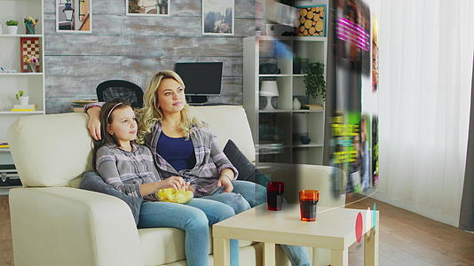在客厅里看智能电视的时间显示母亲和女儿的家人在客厅里视频的预览图