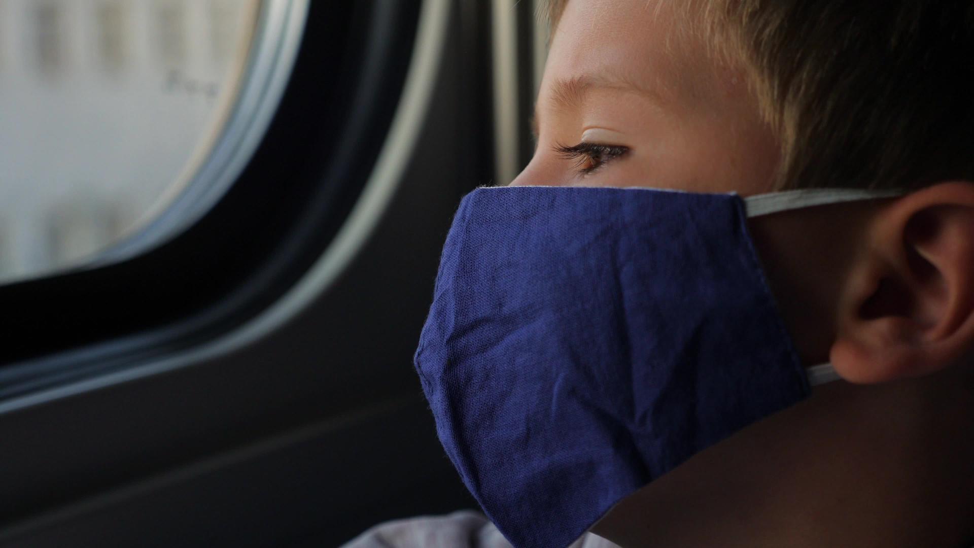 一个戴着口罩看火车窗的年轻男孩视频的预览图