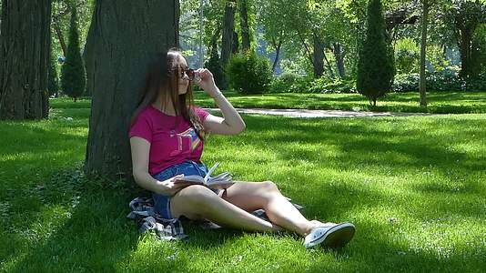 年轻女孩在一个美丽的公园里视频的预览图