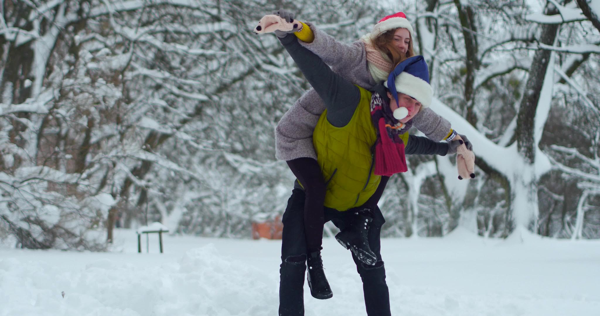 快乐的年轻夫妇在冬季公园装扮近亲视频的预览图