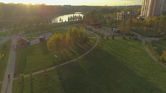 绿色城市公园秋季日落空中观光无人飞机向前飞行视频的预览图