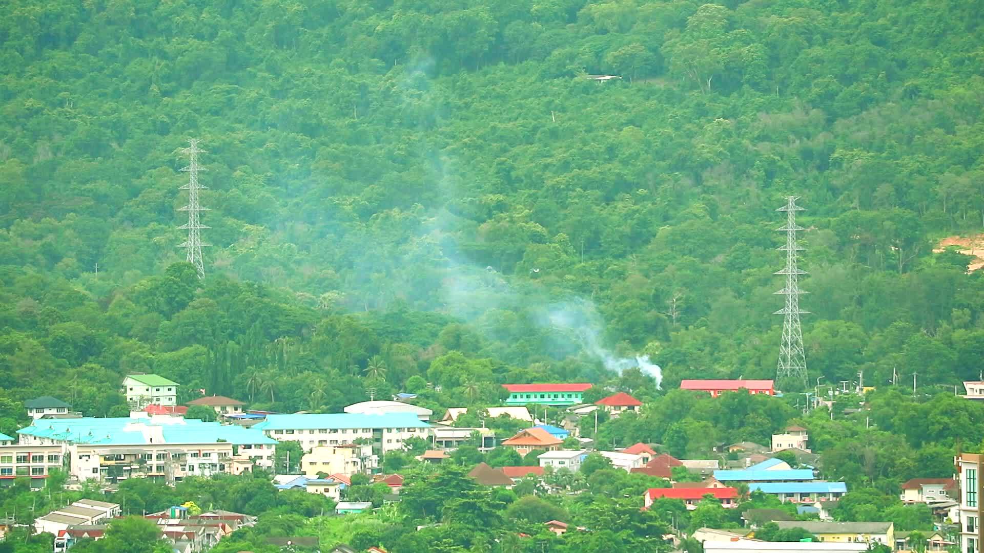 山区和山丘上村庄的草原燃烧着城市的烟雾视频的预览图