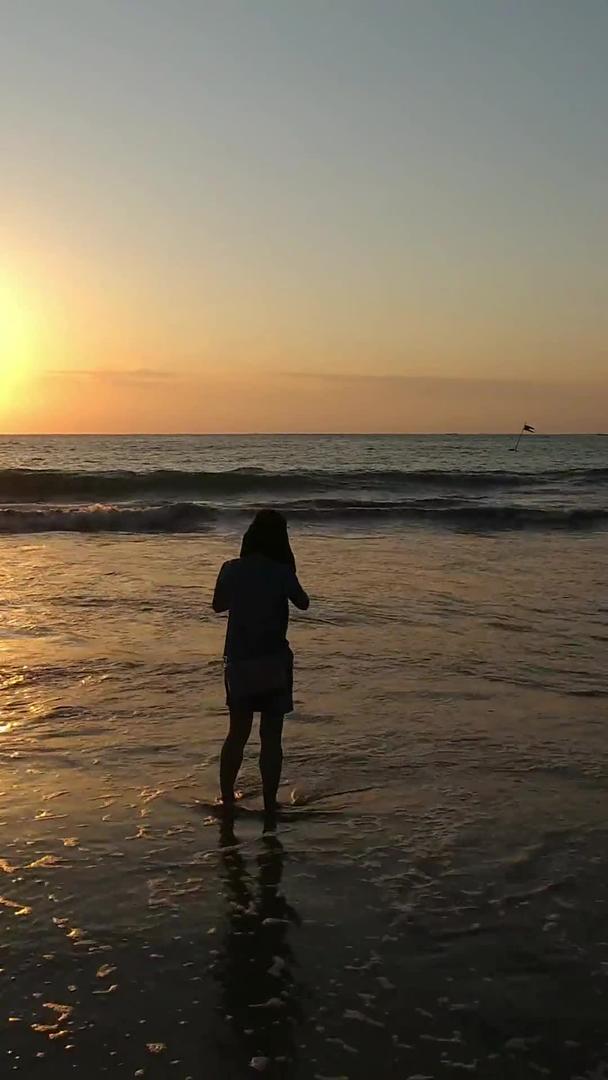 日落时分在海边玩水的人高清视频视频的预览图