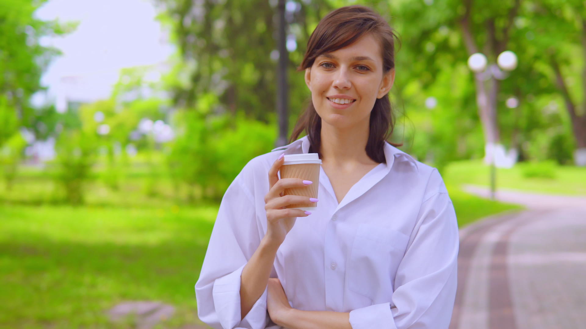 夏天穿着白衬衫的年轻女子在街上散步喝咖啡(夏天)视频的预览图