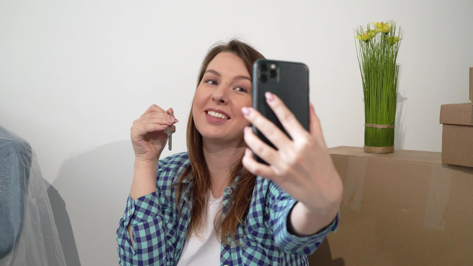 一个年轻女子在手机上自拍搬新公寓回家箱子视频的预览图