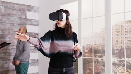 女性建筑师在空公寓中使用虚拟现实护目镜视频的预览图