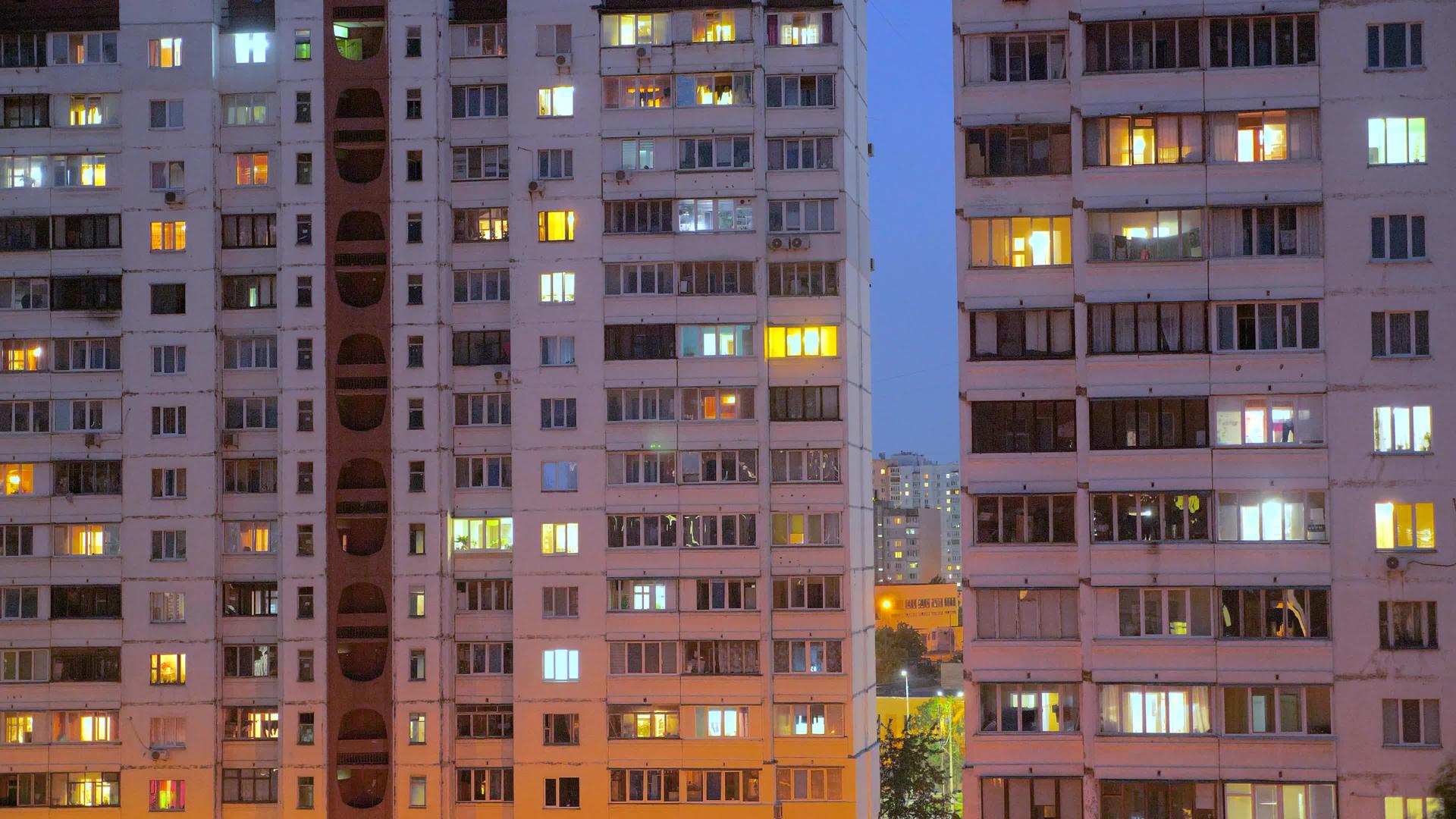 从黄昏到晚上与居住在建筑物中的人们一起使用公寓窗户的时间太长了电力概念视频的预览图