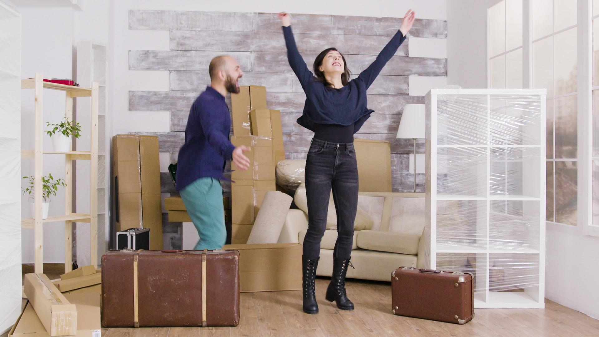 快乐的年轻夫妇跳进他们的新公寓视频的预览图