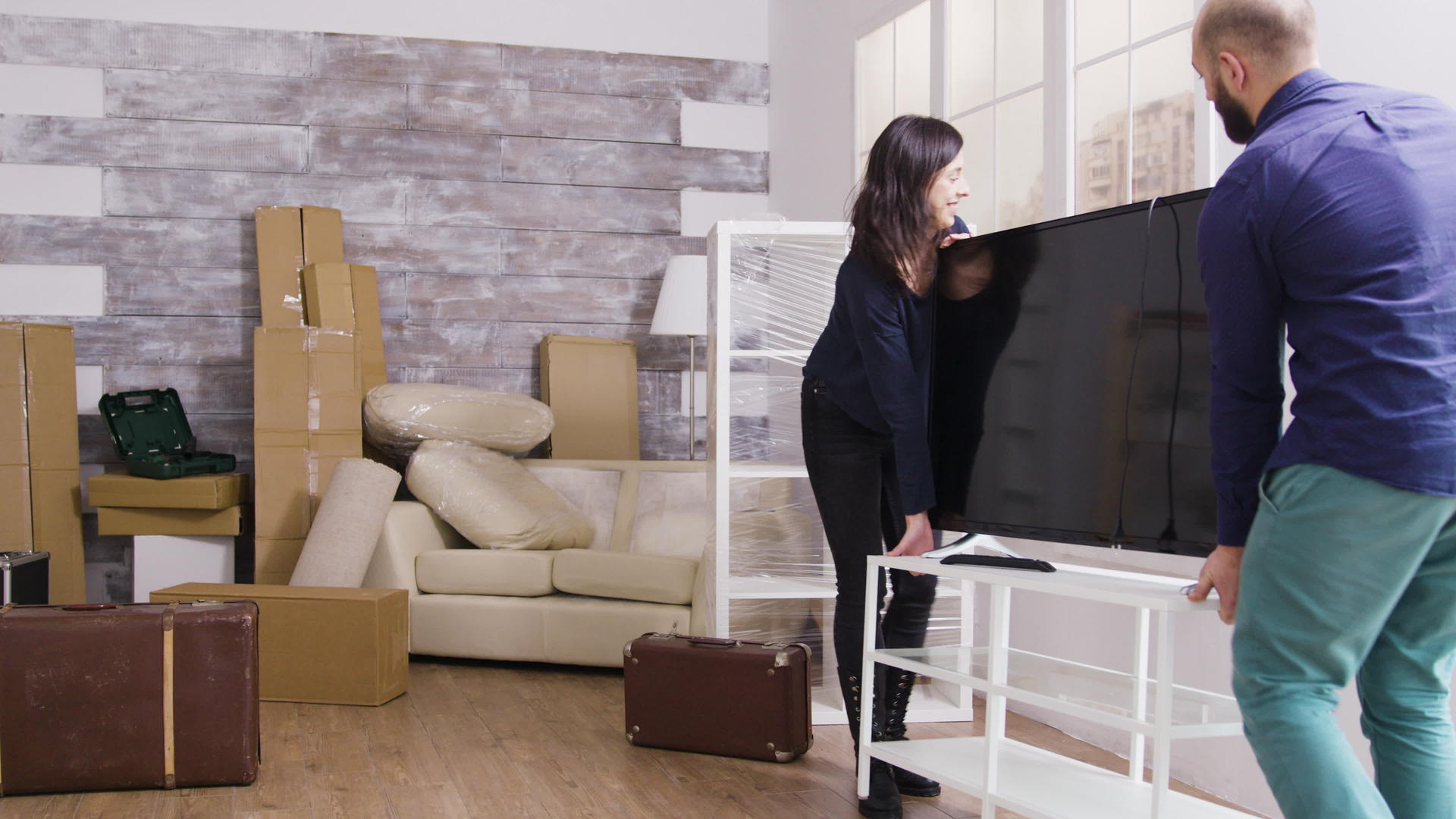 年轻夫妇在新公寓里带着大电视视频的预览图