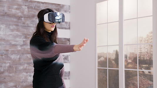 美丽的女性家庭设计师使用虚拟现实护目镜视频的预览图