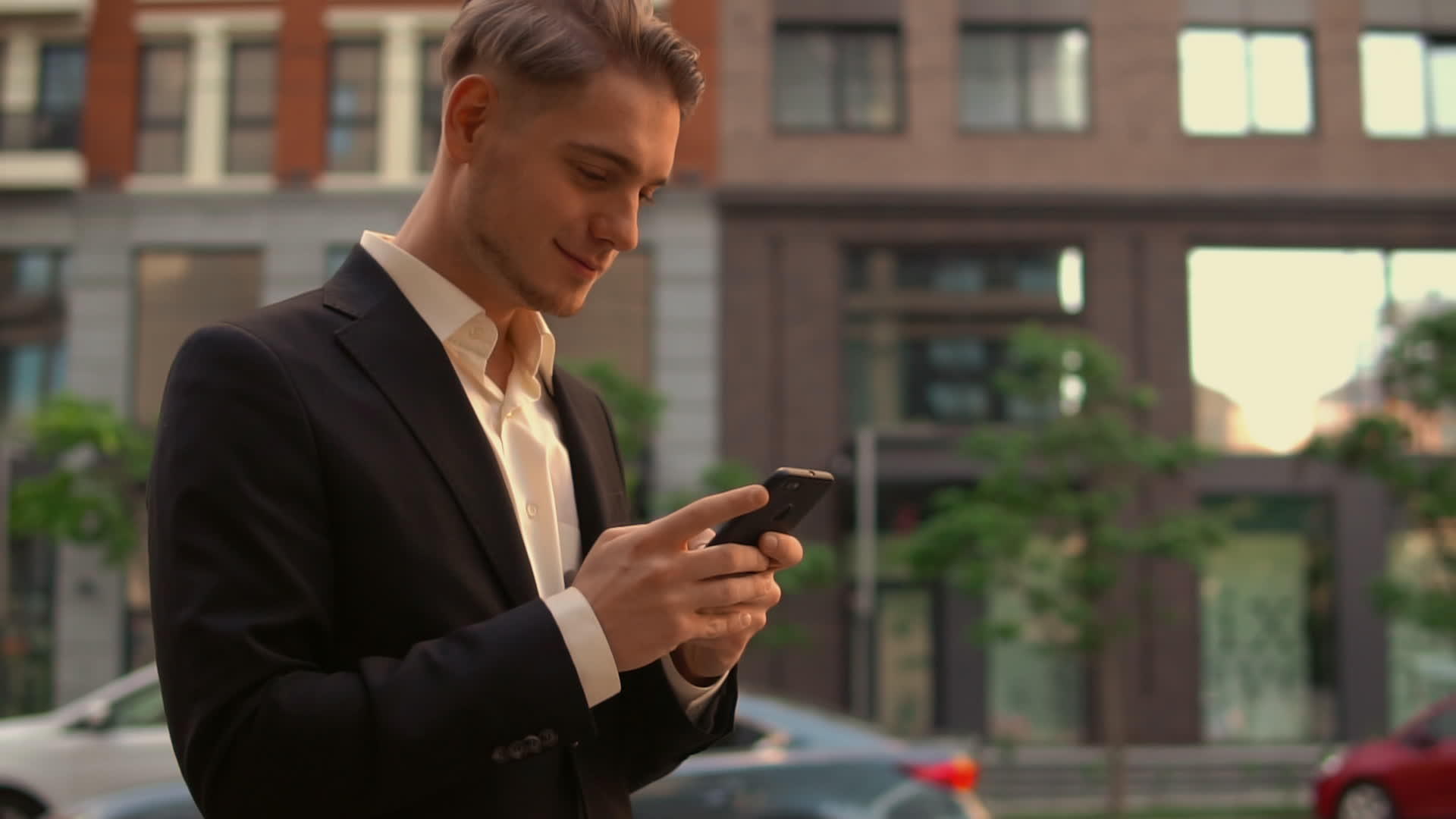 微笑的商人在城市里使用手机视频的预览图