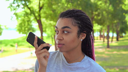 有户外智能手机背景的发型女性笑肖像视频的预览图