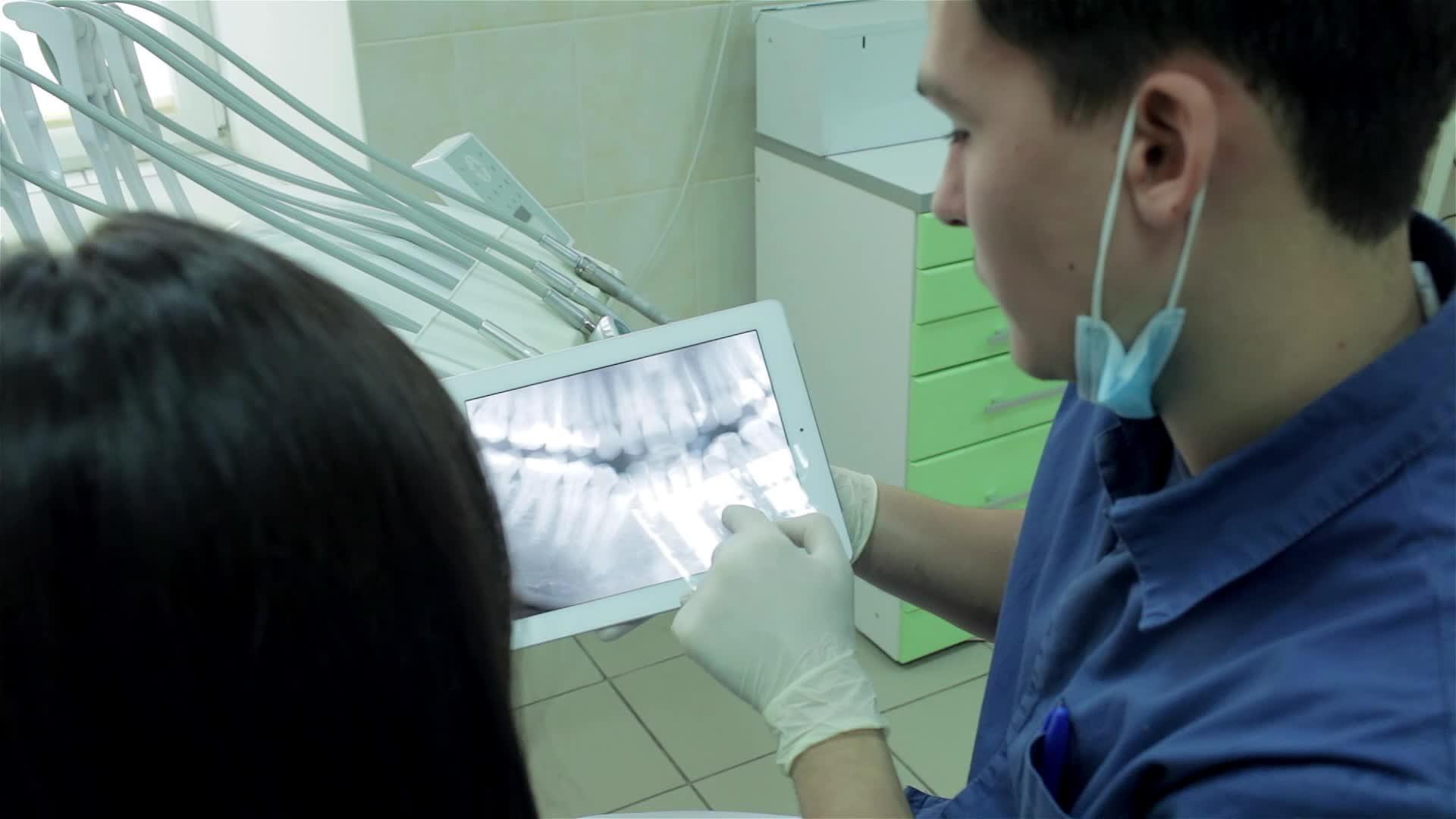 牙医在药片上展示了患者的X光片并告诉她正畸方法视频的预览图