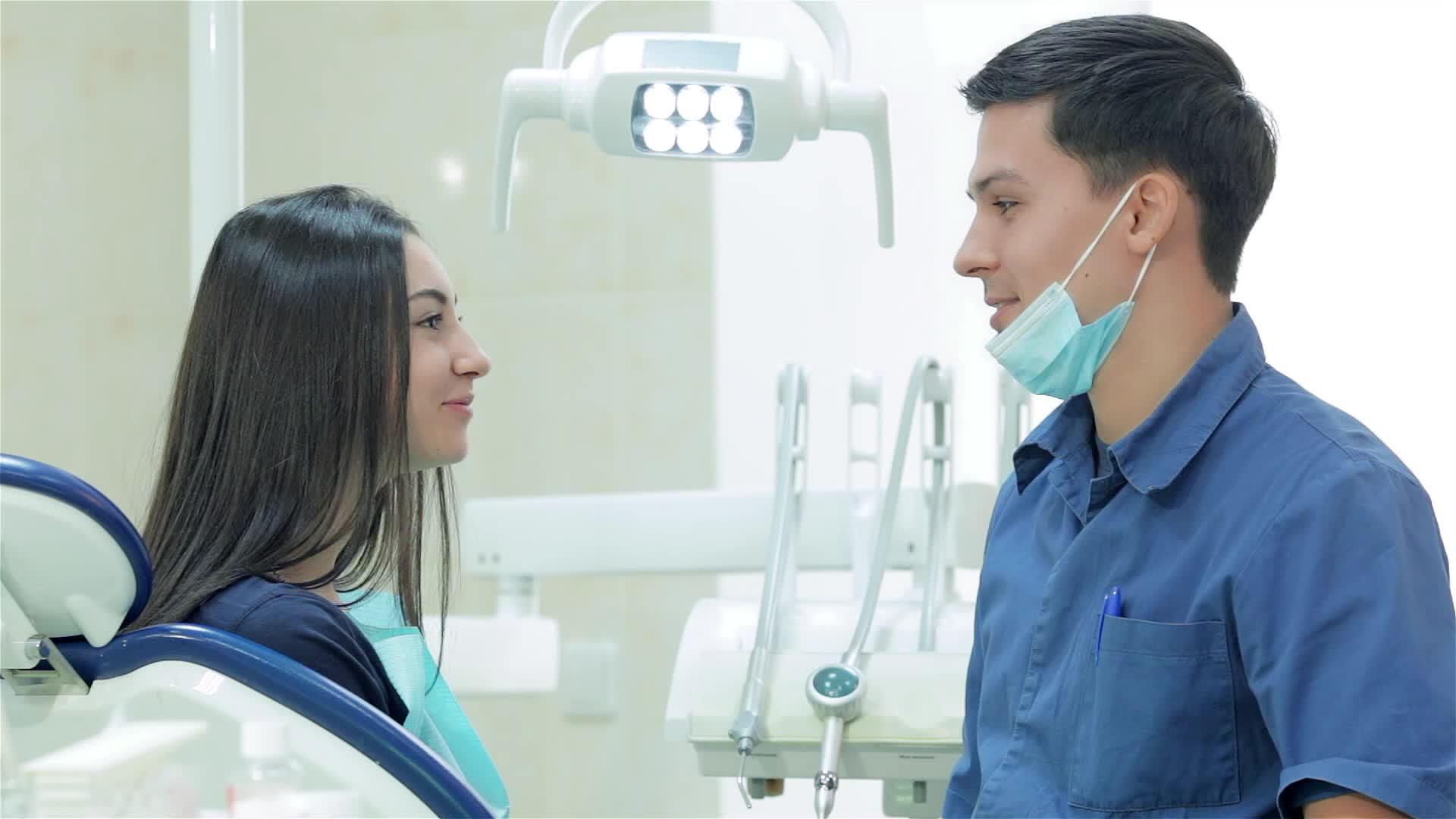 在镜头中牙医和年轻女性患者的牙齿直接微笑视频的预览图