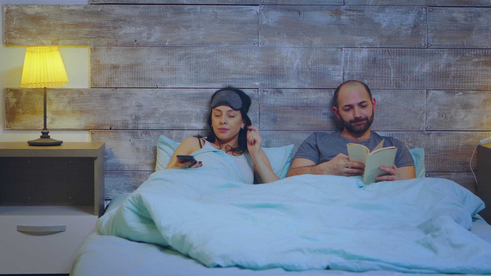 丈夫读书时妻子用手机应用程序打开房间的主灯视频的预览图