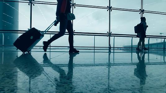 4K实拍机场落地窗背着背包拖着行李走过的旅客视频的预览图