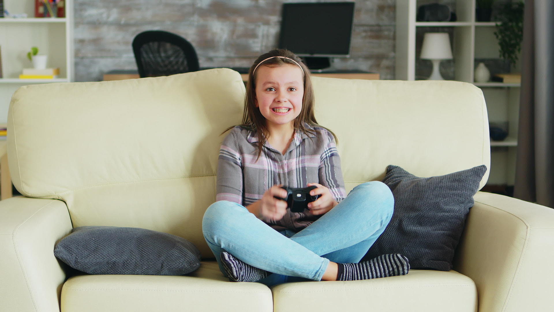 快乐的小女孩用无线控制器玩电子游戏视频的预览图