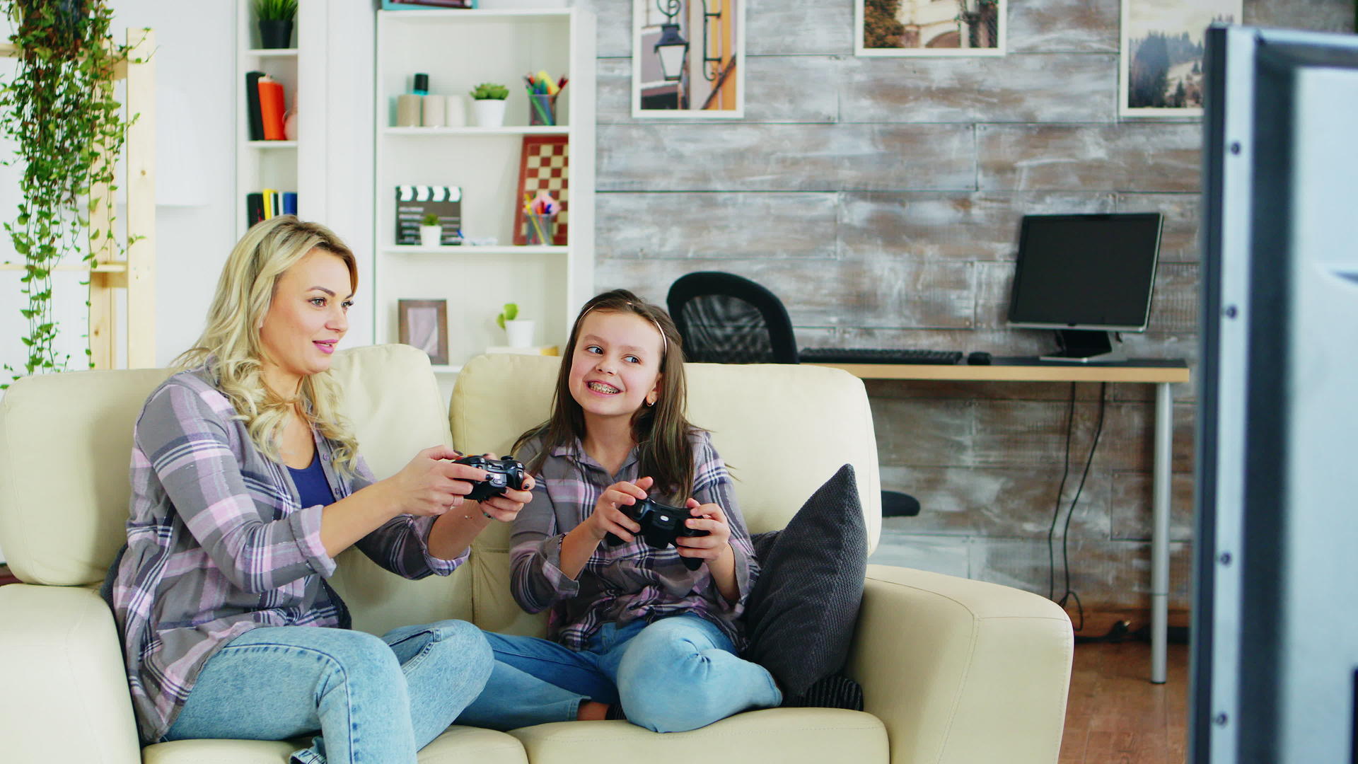 母亲和女儿玩电子游戏视频的预览图