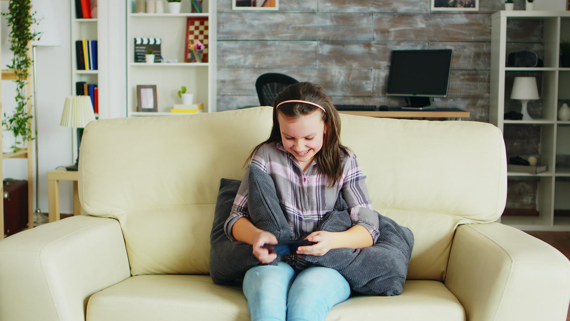 兴奋的小女孩在手机上玩电子游戏视频的预览图