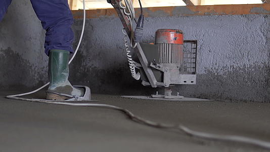 工人们使用电流轮工具完成混凝土地板混凝土表面光滑视频的预览图