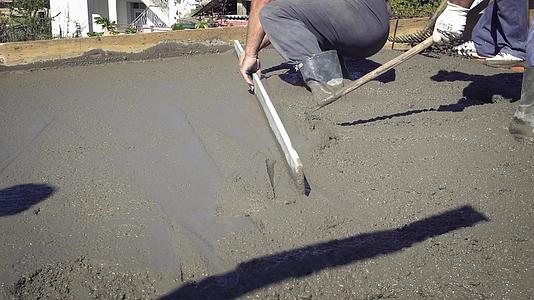 工人用手动工具铺设水泥砂浆制作混凝土地板视频的预览图