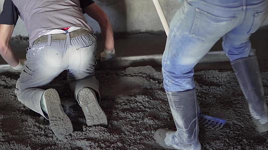 工人们踩着室内水泥地板上的石头视频的预览图