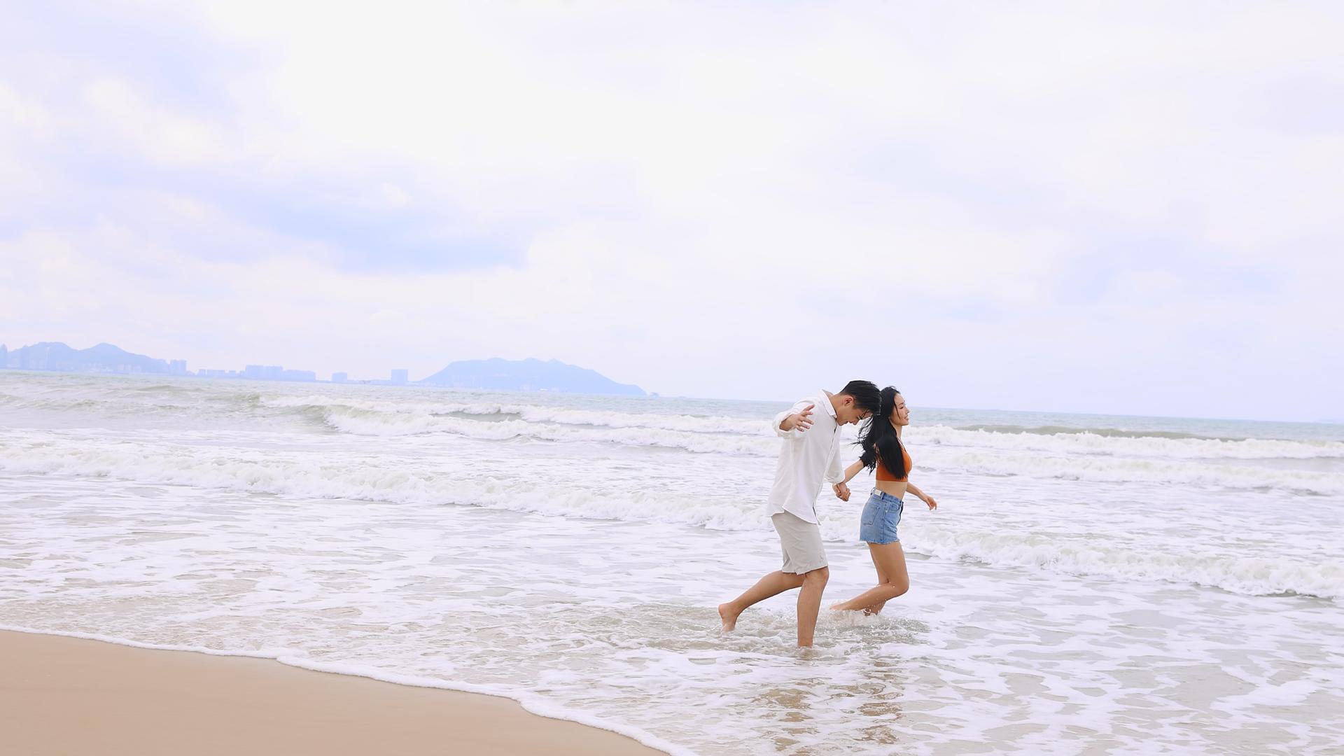 海滩上愉快玩耍的情侣视频的预览图