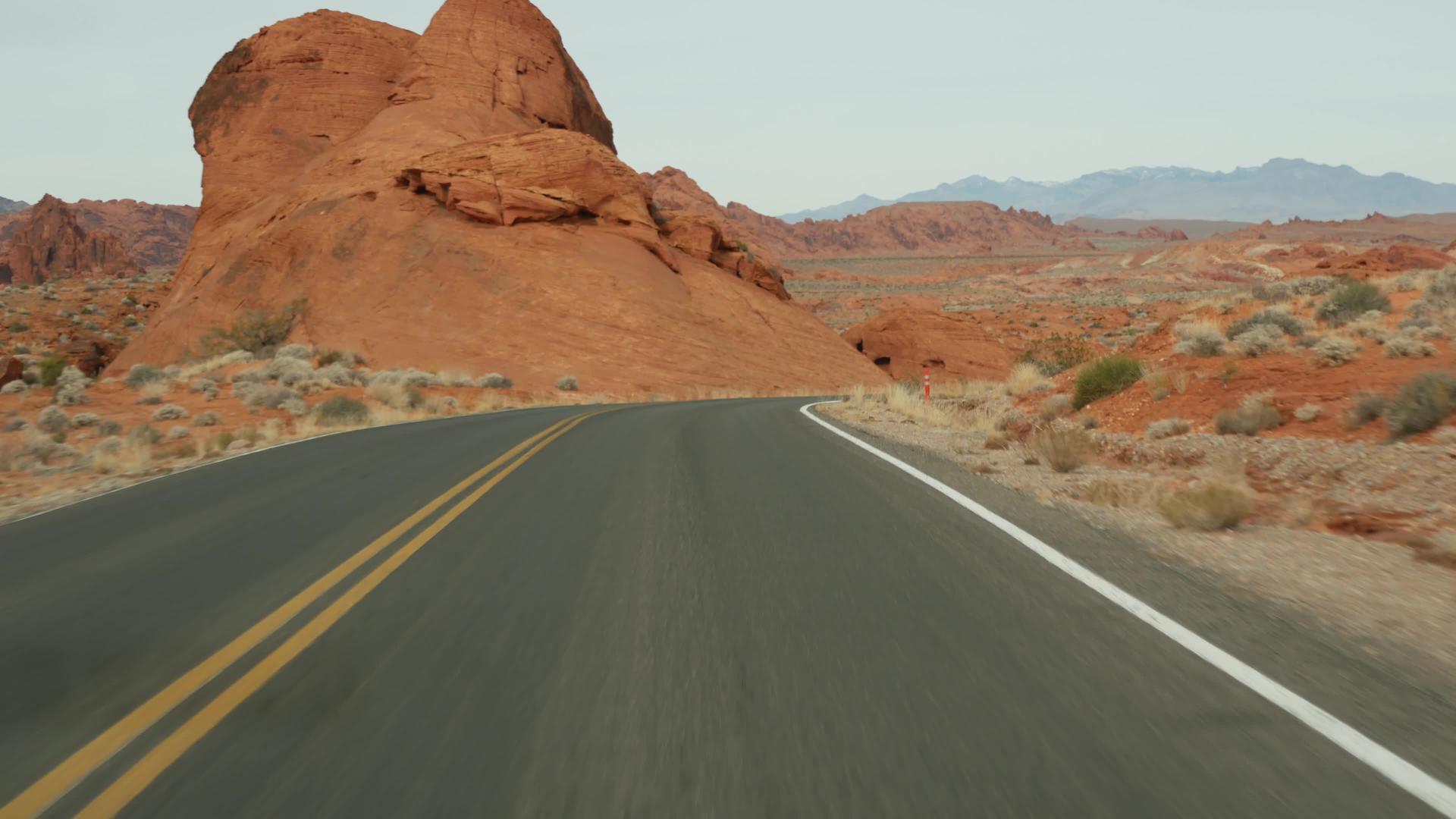 公路旅行在美国内华达州拉斯维加斯的火谷驾驶汽车在美国公路旅行红色外星岩层莫哈韦沙漠荒野视频的预览图