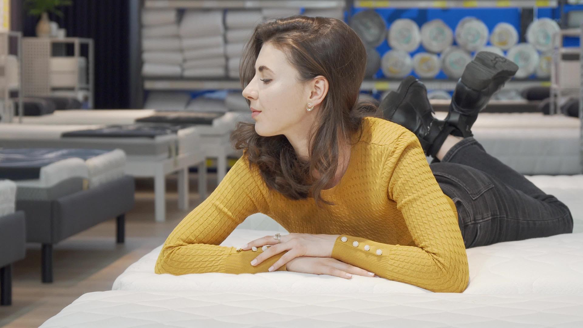 可爱的女人在家具店试床垫视频的预览图