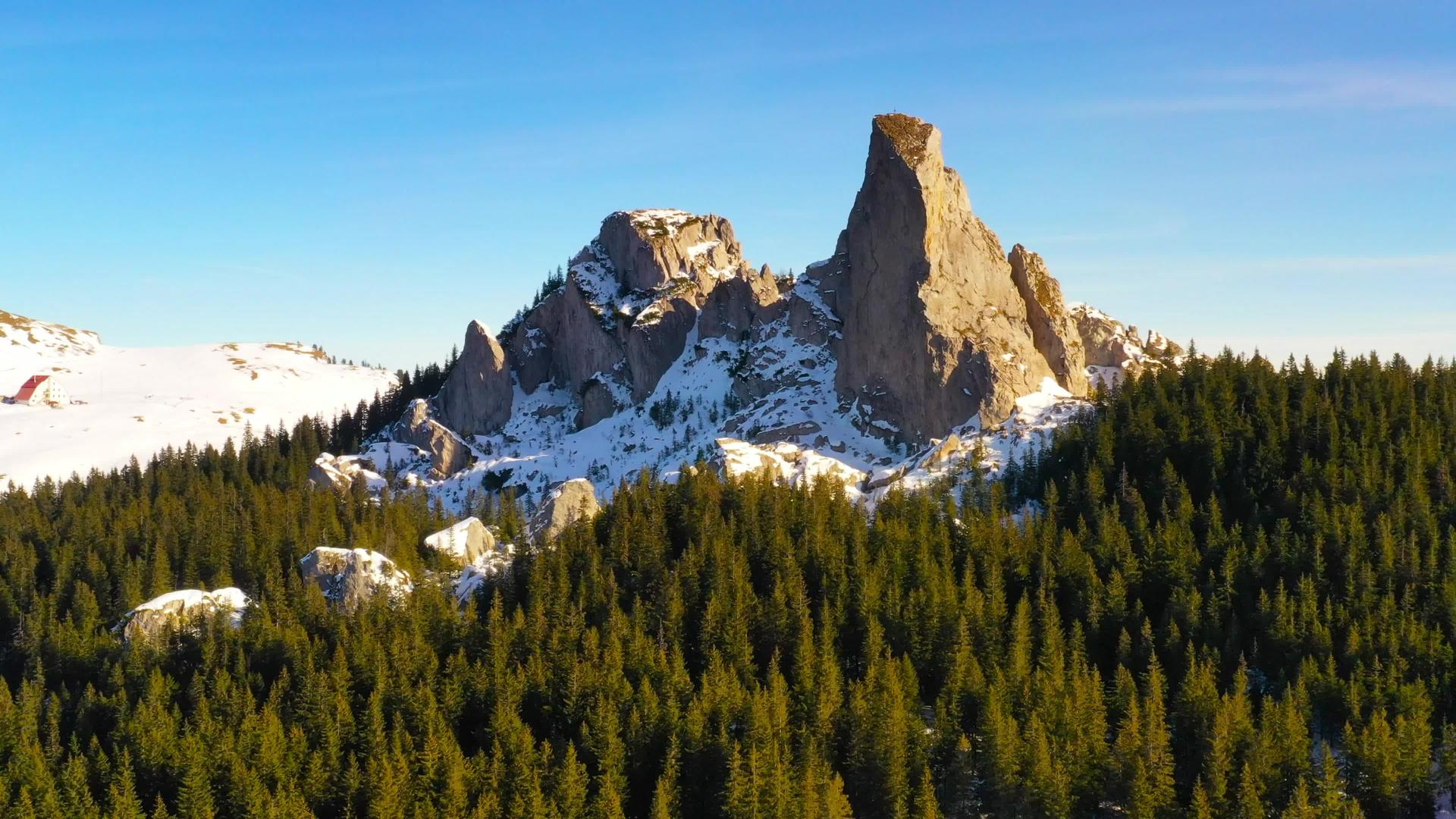 日落时无人驾驶飞机移动环顶岩石在拉劳山脉和空中冬季风景的拉劳山顶上有人的石头视频的预览图