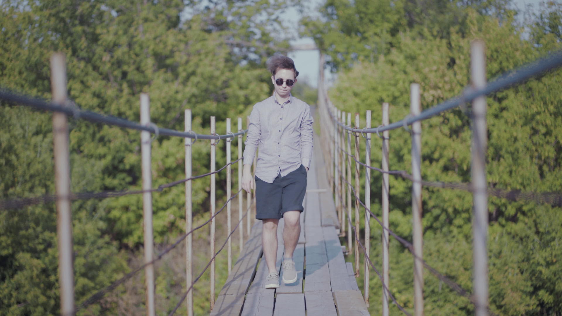 这家伙走在森林的悬浮桥上视频的预览图