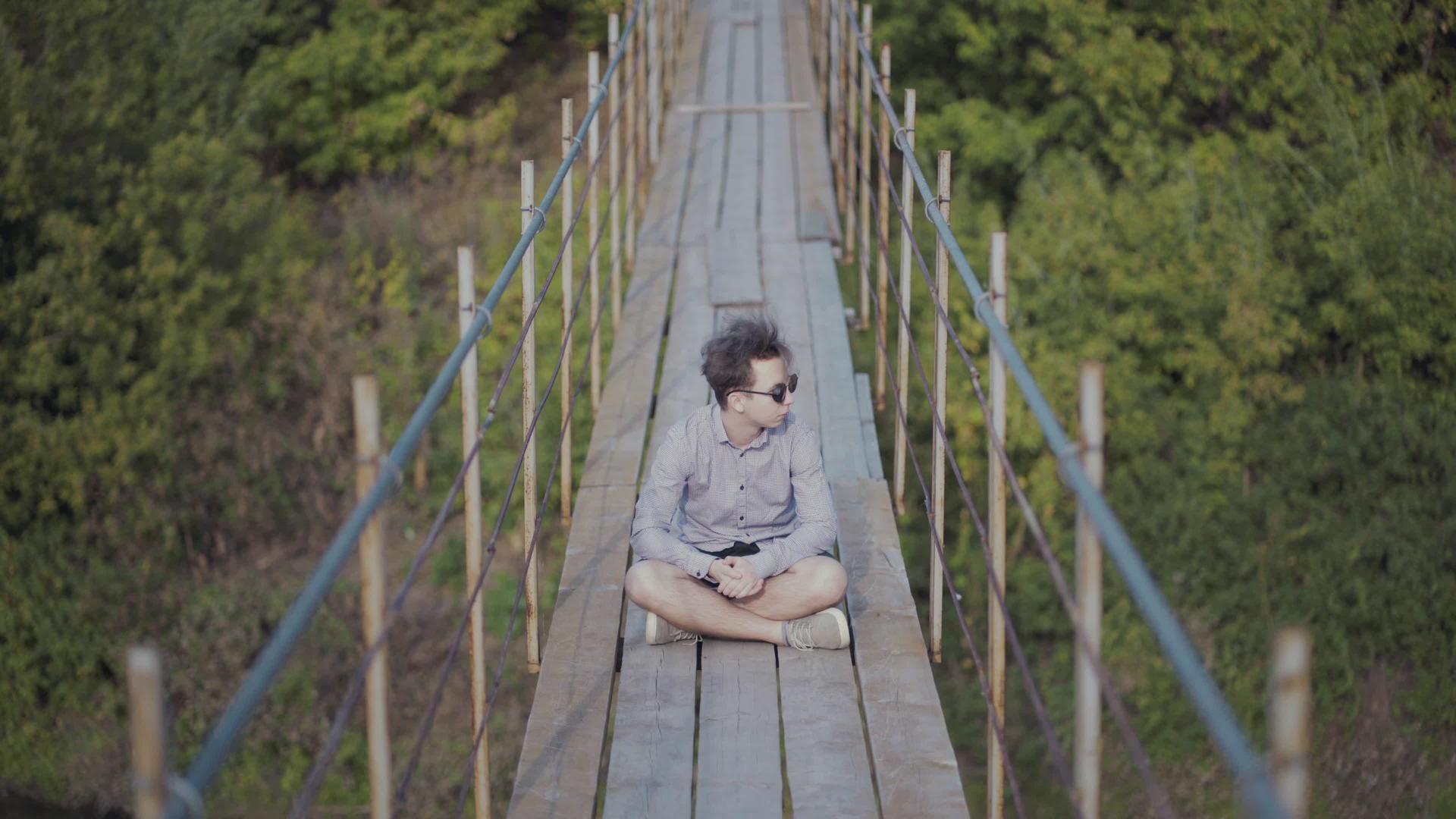 坐在森林的悬浮桥上视频的预览图