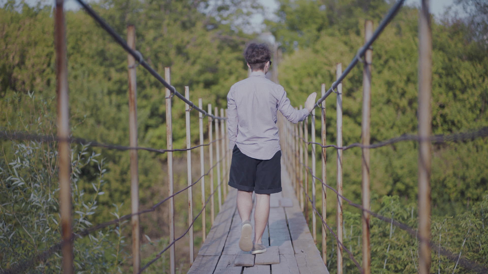 这家伙走在森林的悬浮桥上视频的预览图