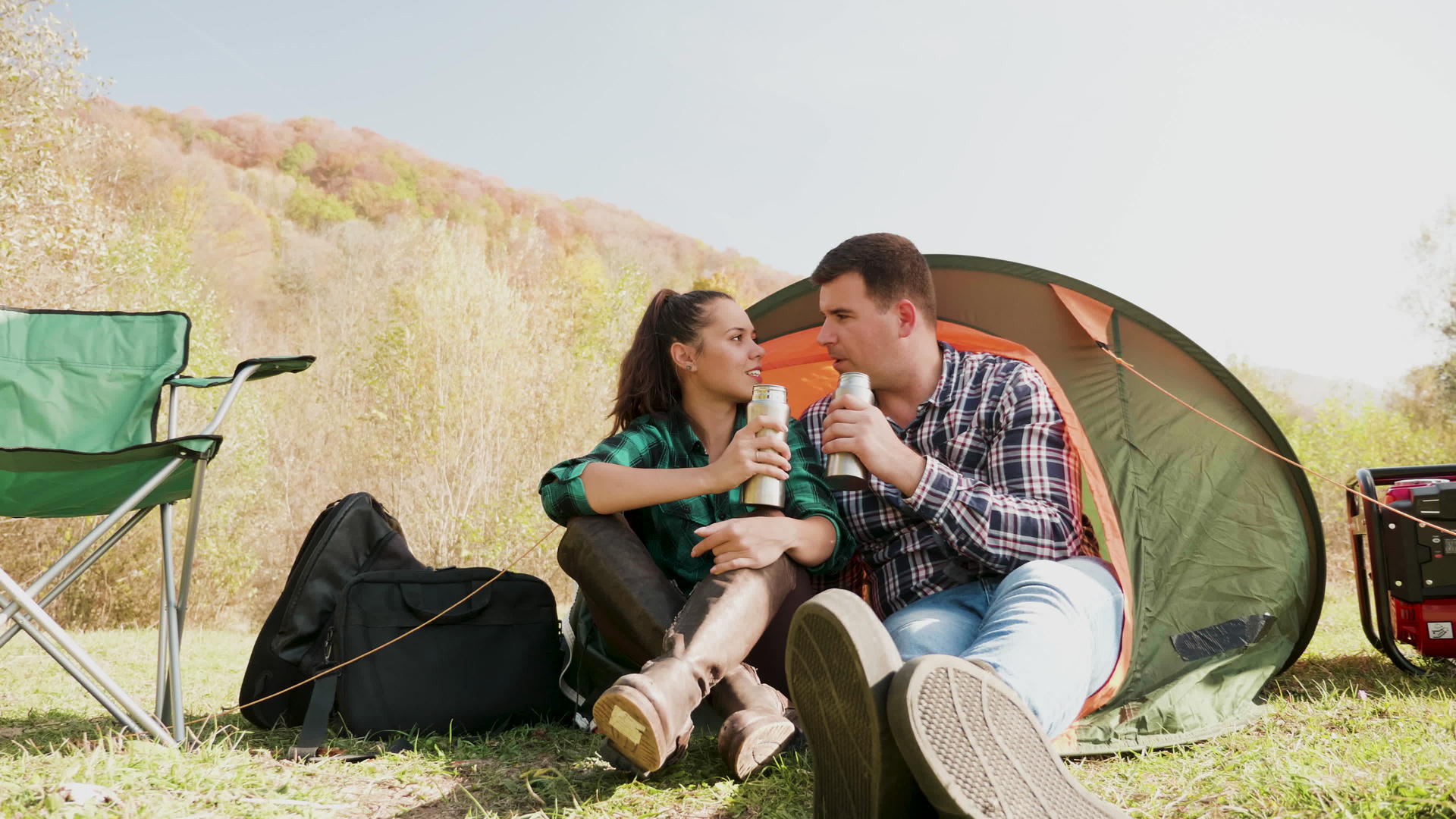 一对夫妇在露营帐篷前一起喝酒视频的预览图
