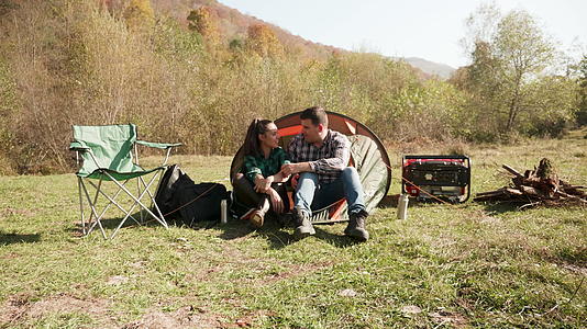 美丽的年轻夫妇在露营帐篷前交谈视频的预览图