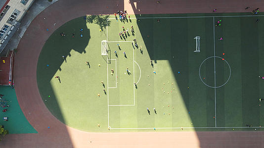航拍城市校园体育课足球场上运动健身的学生4k素材视频的预览图