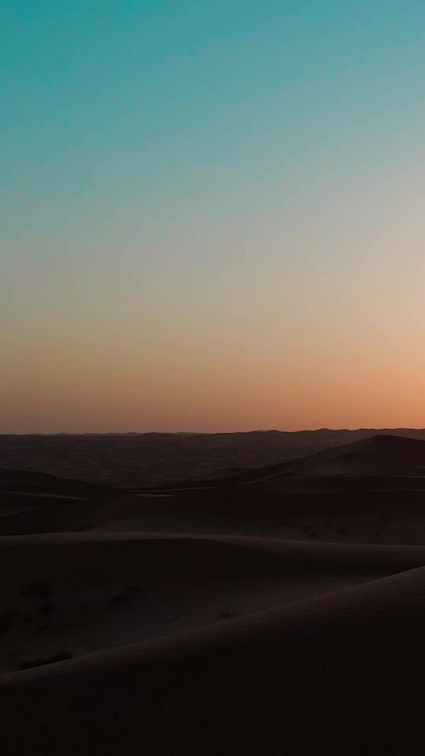 人物在沙漠夕阳下的航拍剪影视频的预览图