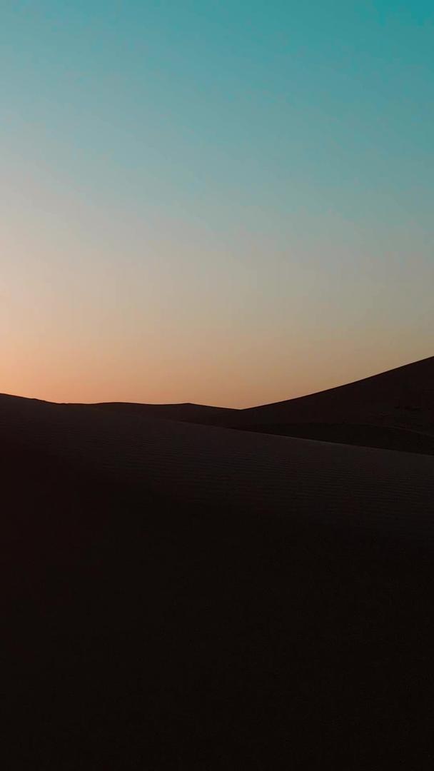人物在沙漠夕阳下的航拍剪影视频的预览图