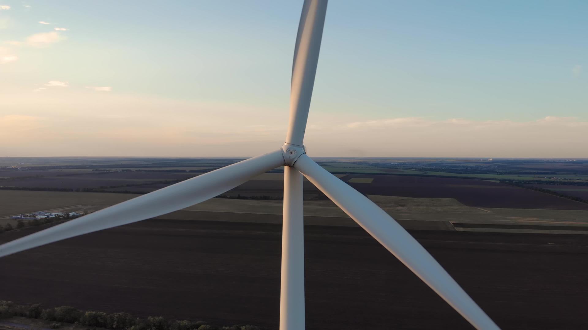 无人机在黄昏和日落时带有农田的风力涡轮机旋转转子叶片乌克兰可再生能源风车发电视频的预览图