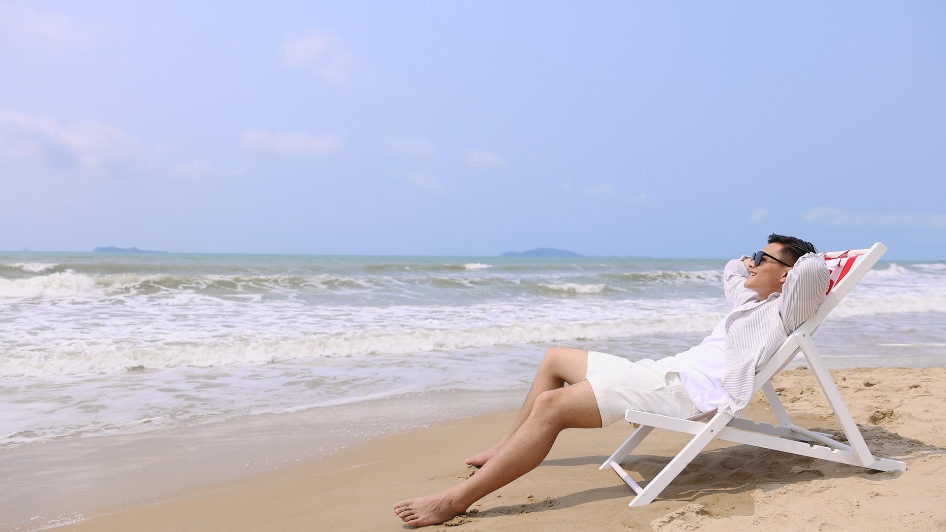 沙滩椅上享受假期的男性青年视频的预览图