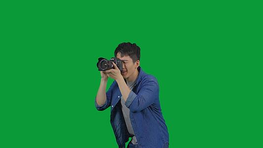 4K绿幕男青年用相机拍照视频的预览图