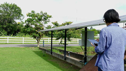 农民使用平板电脑监测太阳能电池在农场的泵送农业电力管理采用移动应用技术视频的预览图