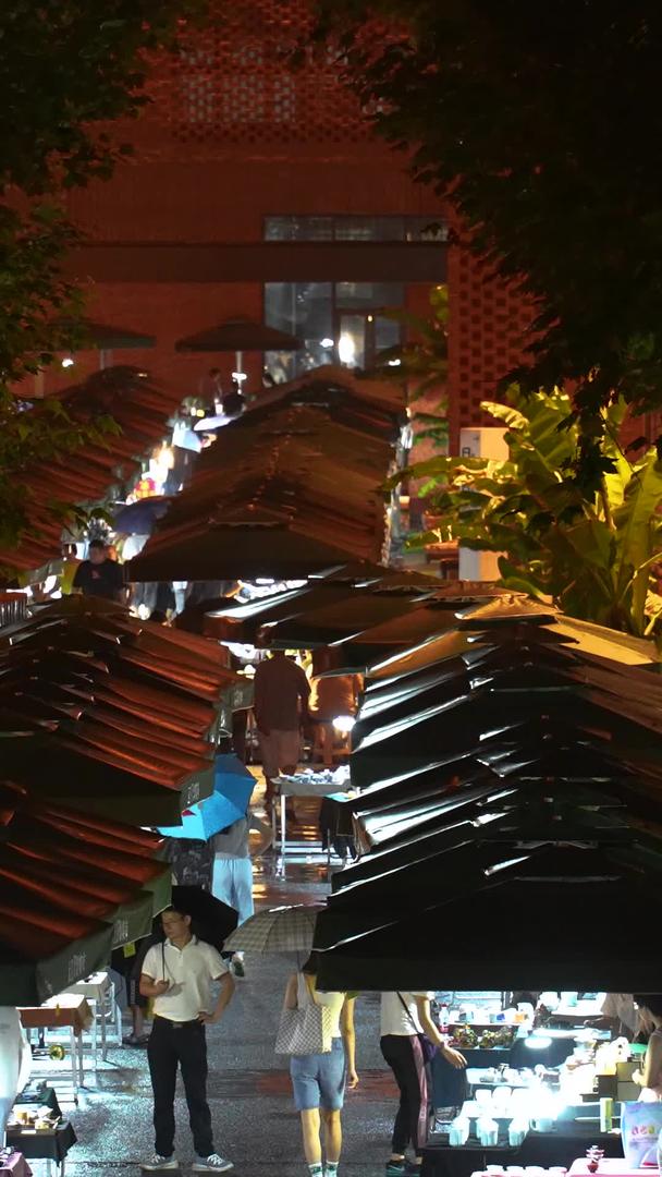 城市雨夜打着伞集市购物的行人素材视频的预览图